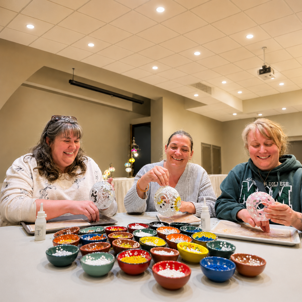 Friends creating mosaic lamps together in a workshop